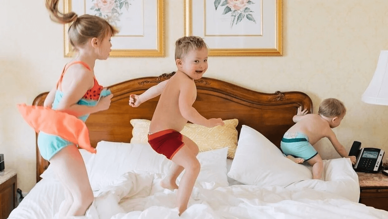 siblings jumping on the bed