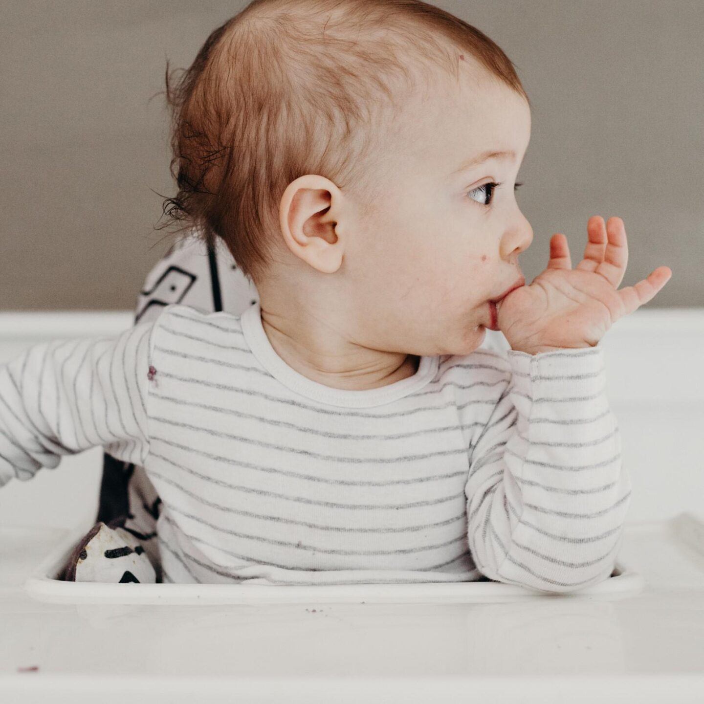 baby eating food from its finger