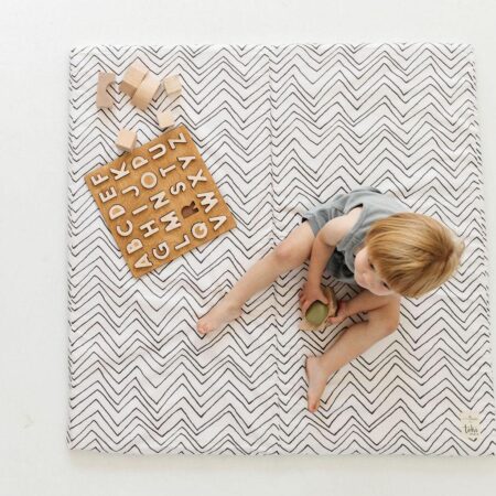 toddler playing on striped mat