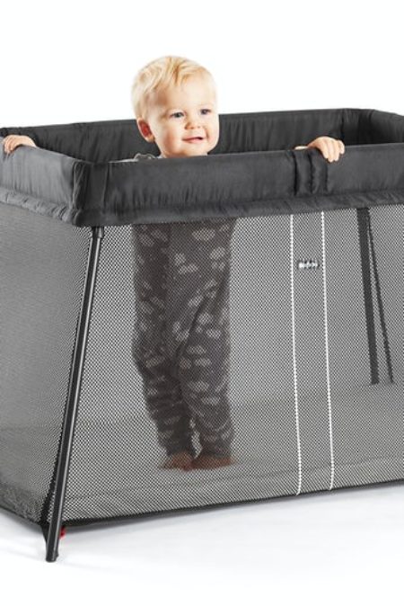 toddler standing in portable crib