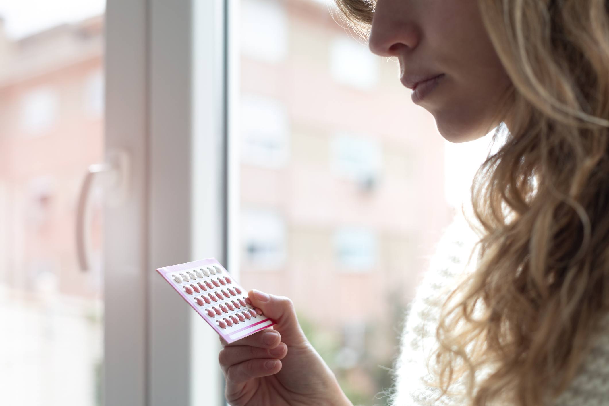 woman holding birth control pills - can you get pregnant on birth control