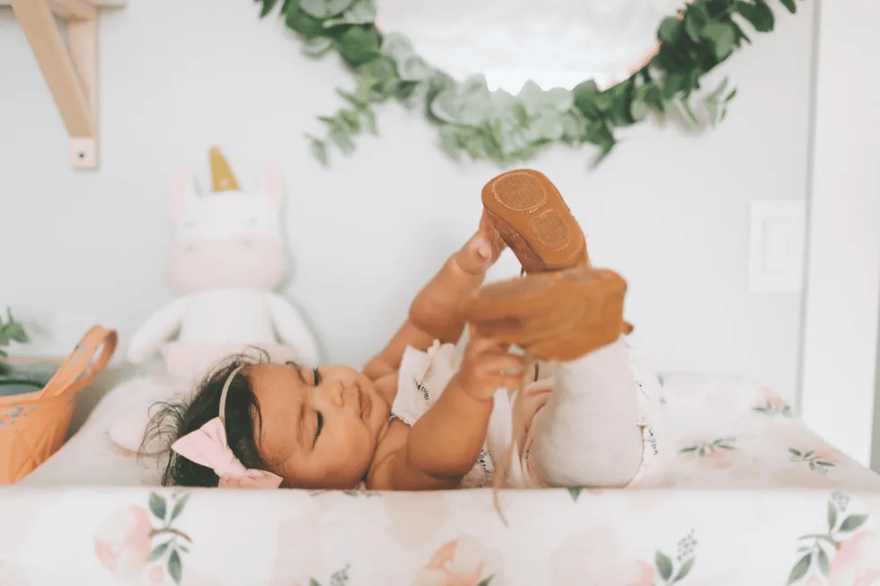 baby grabbing toes, one of the 7-month developmental milestones for baby