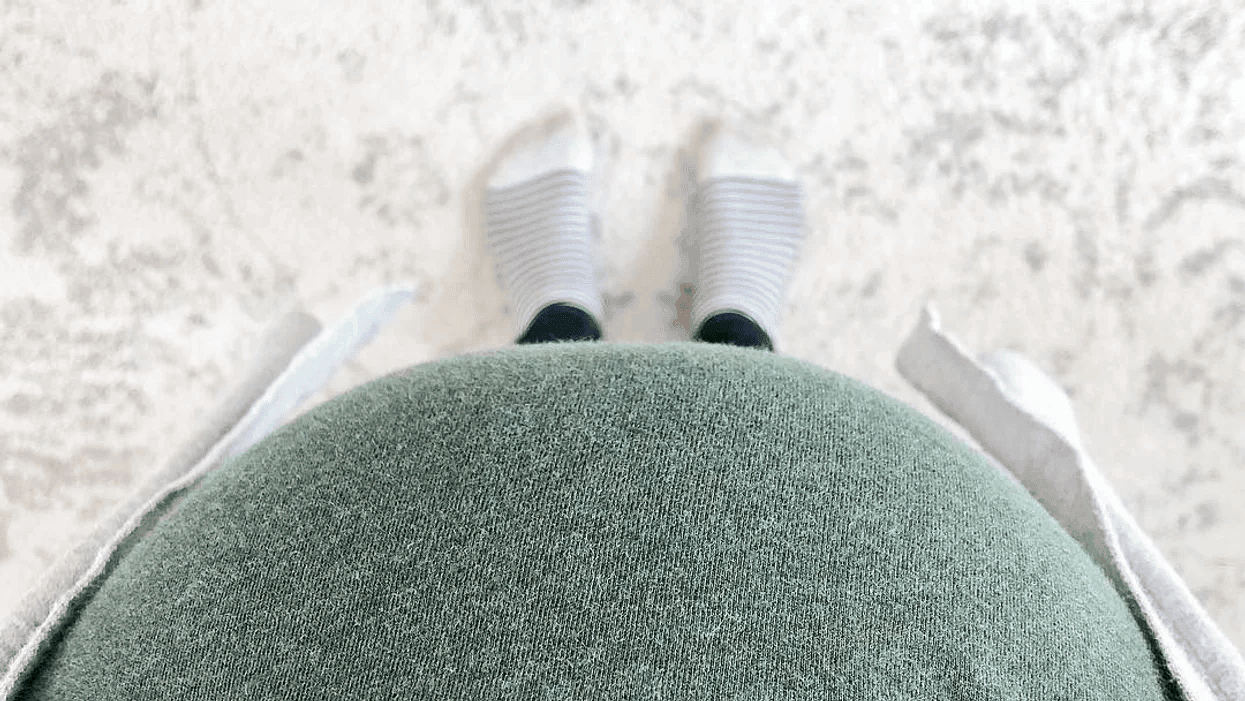 image of woman looking down at her pregnant belly to her toes