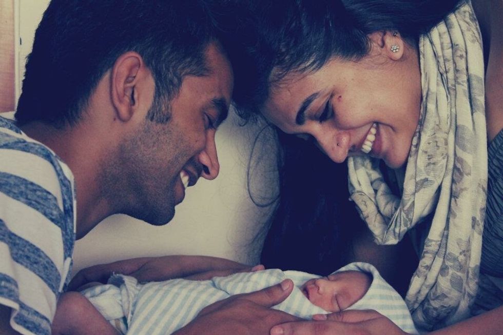 couple holds newborn baby smiling - should i have another baby