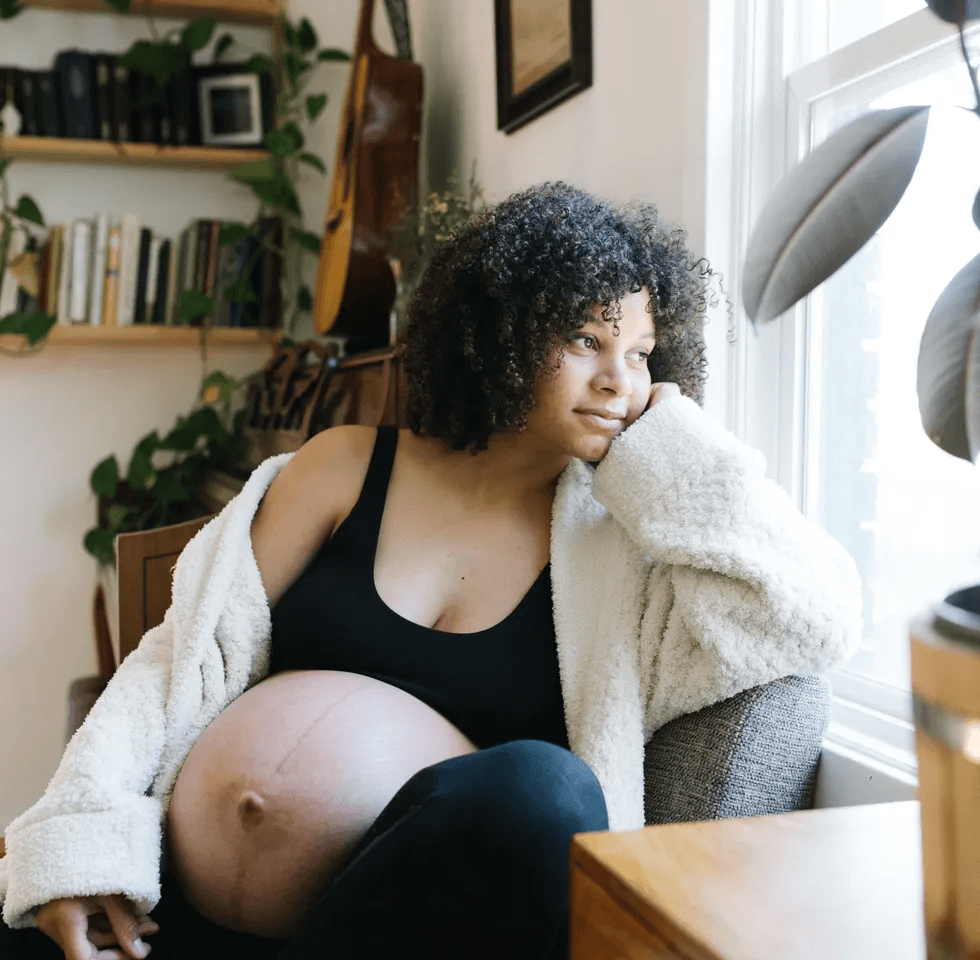 pregnant woman looking out a window