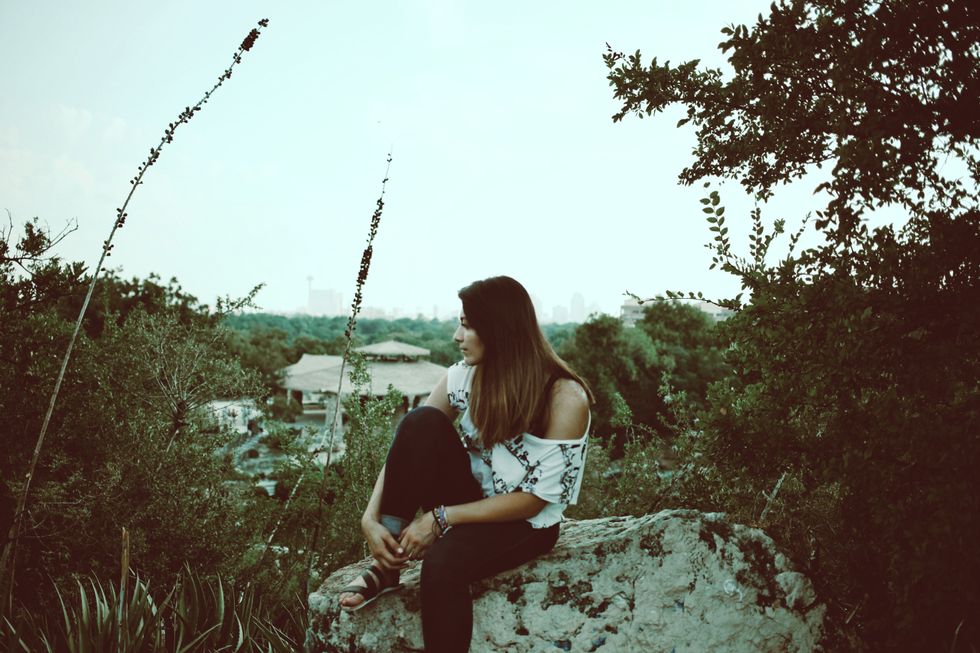 Woman sitting on a rock while hiking - questions to ask at preconception visit