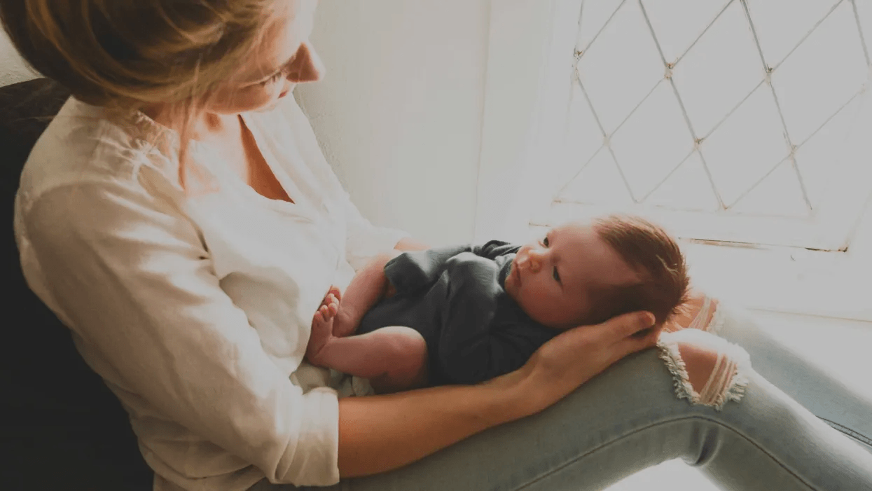 mom holding newborn baby on her lap- what do stay at home moms do