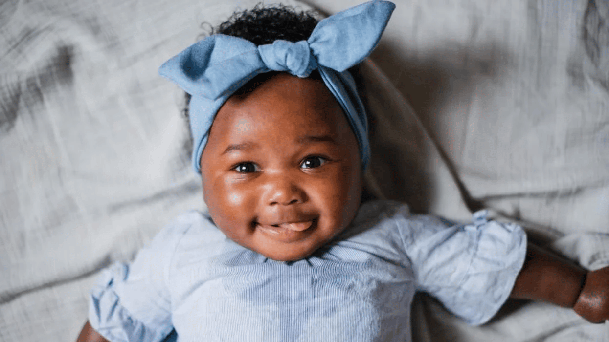 baby wearing a blue bow smiling at the camera - 5-month-old baby feedings schedule