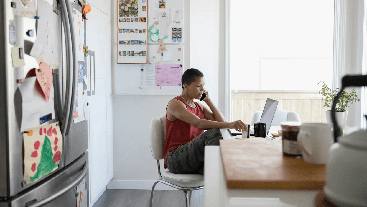 person-sitting-at-a-table-on-a-computer-and-on-the-phone