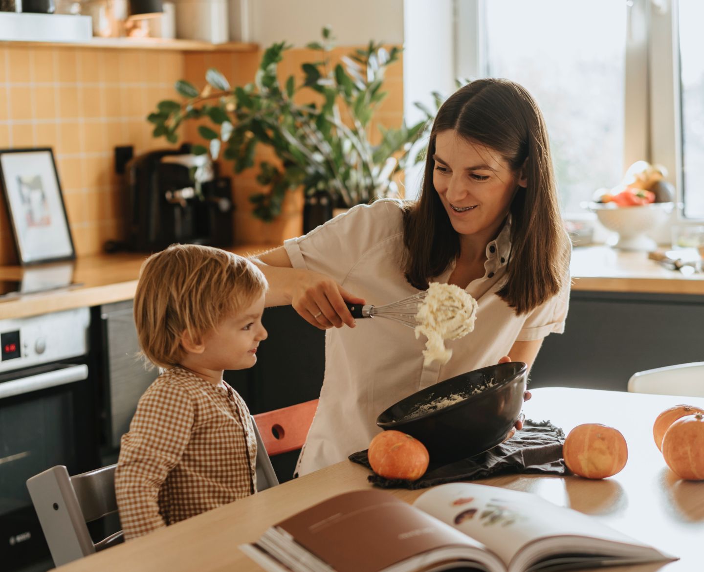 mom and kid making halloween food Motherly