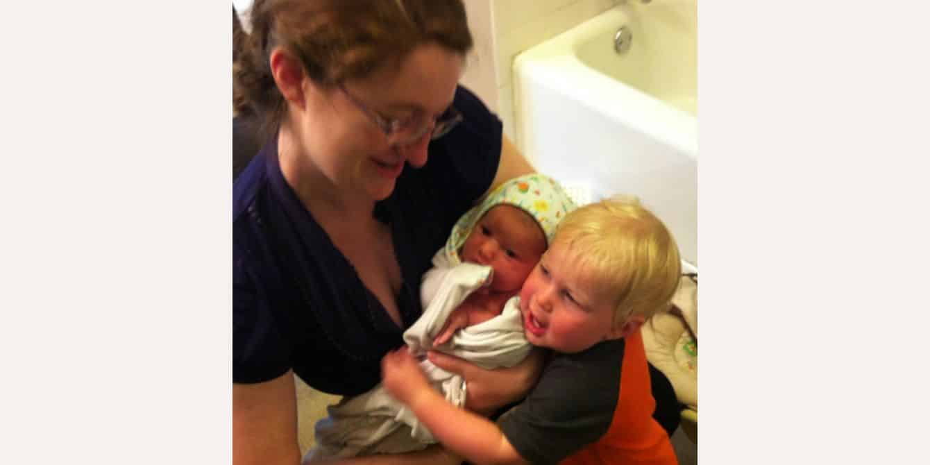 mom holding two babies - essay on feeling alone and isolated with postpartum depression