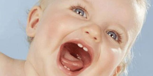 cheerful, open-mouthed infant who's learning about baby speech development