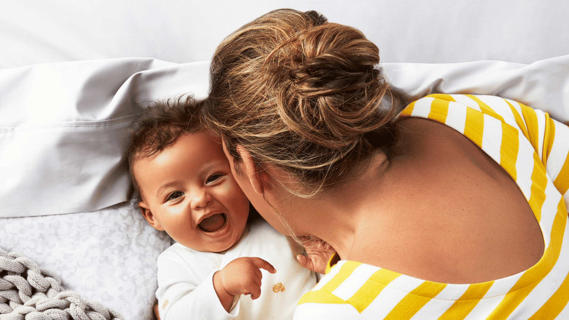 mom kissing happy baby