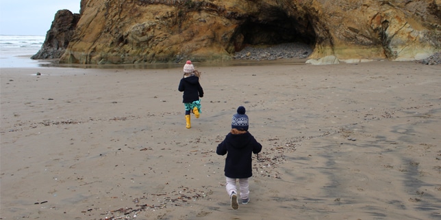 two kids running on the Portland coast