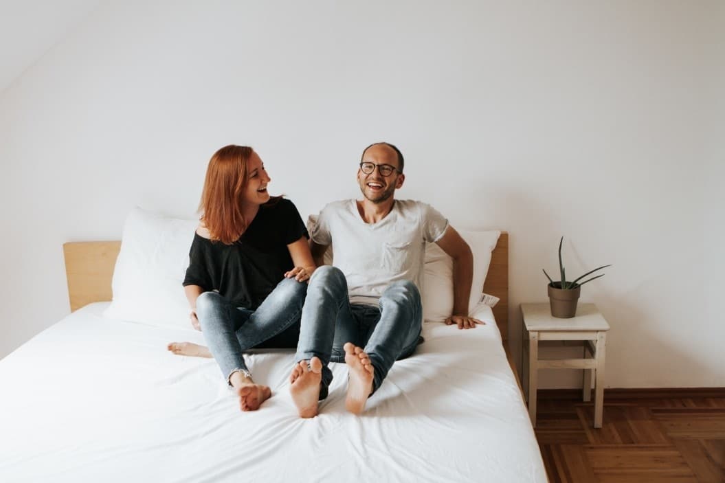 couple laughing together in a bed