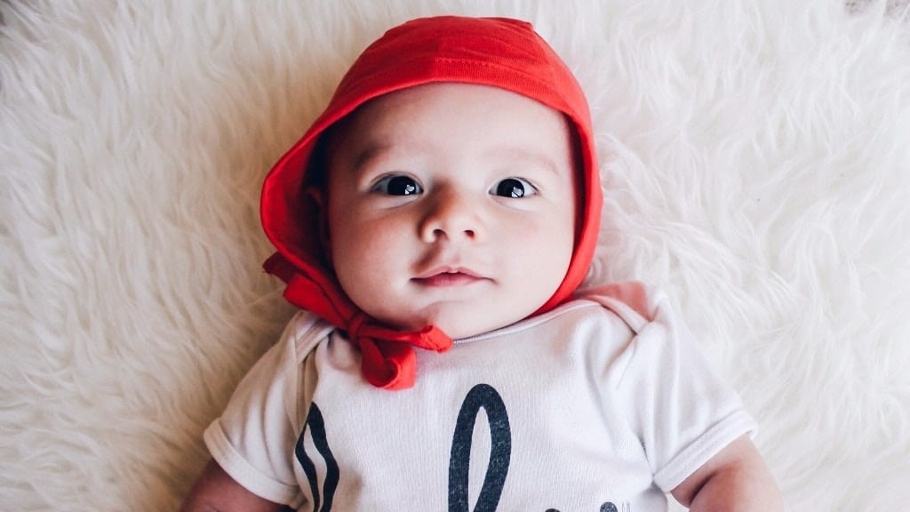 baby wearing a red cap