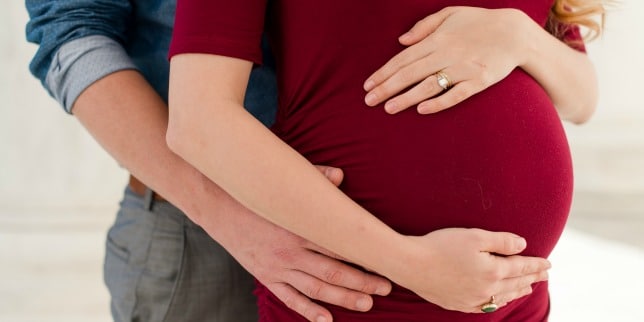 man and woman embracing her pregnant belly