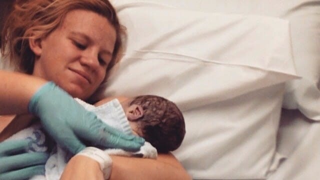 mom holding newborn baby in a hospital bed