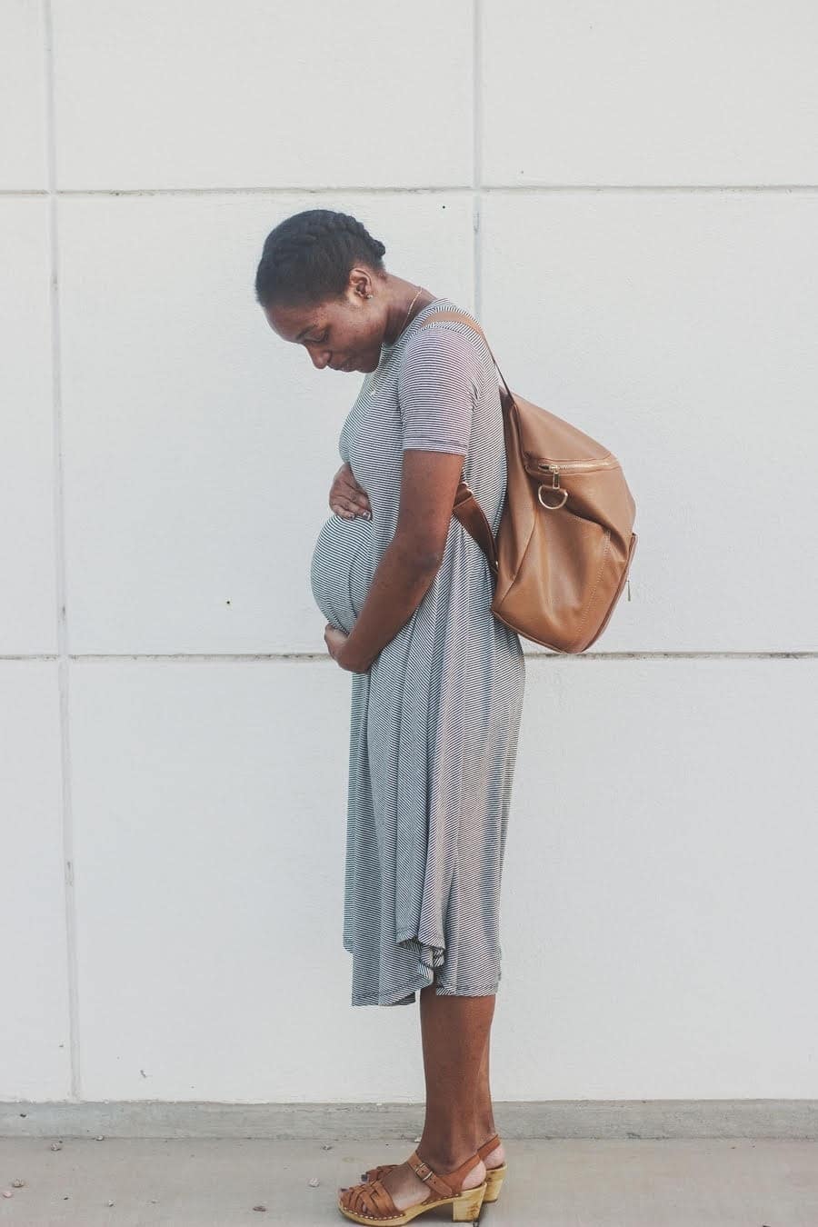 pregnant mother cradling her belly, worried that her baby is breech