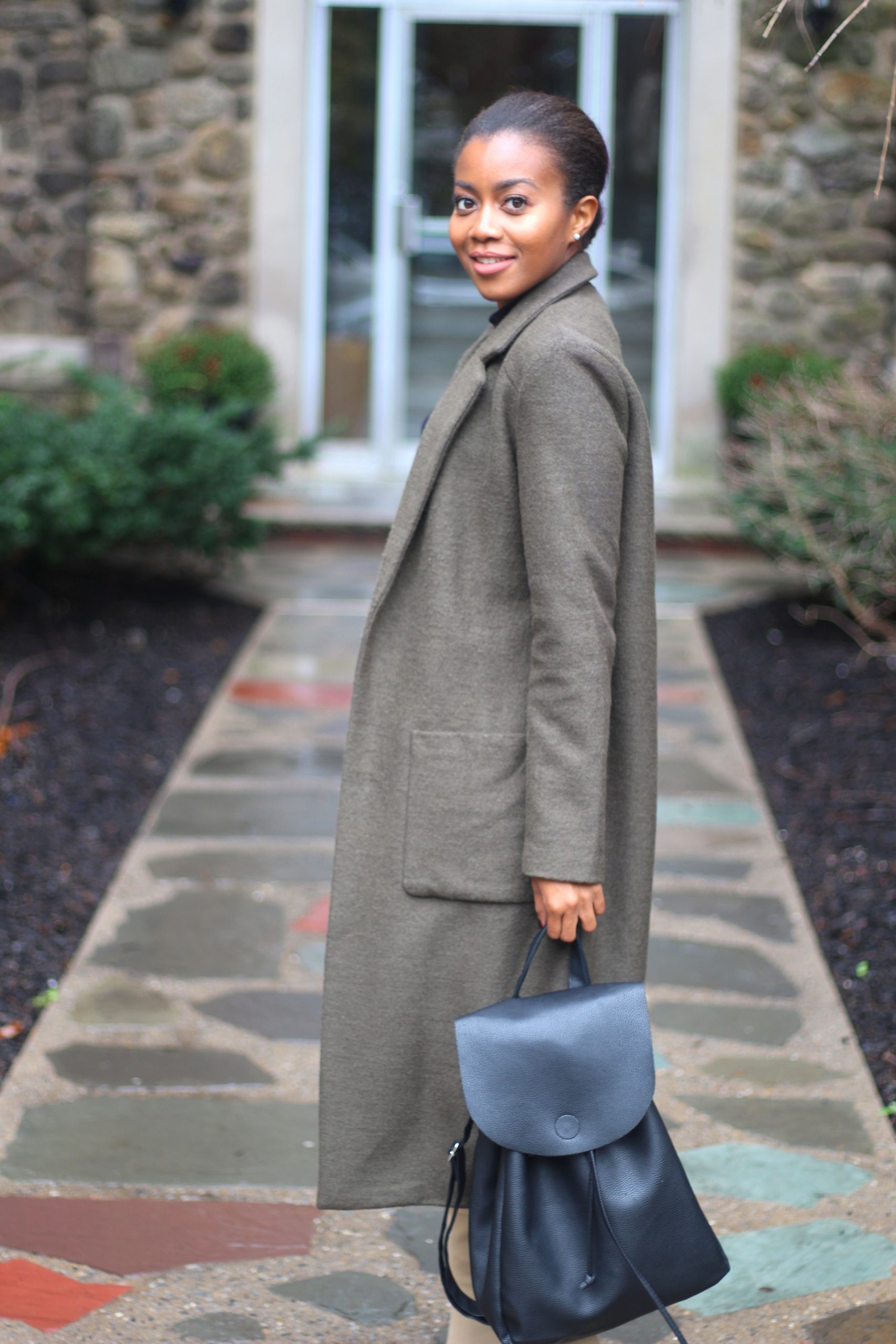 Woman wearing a coat and holding a briefcase