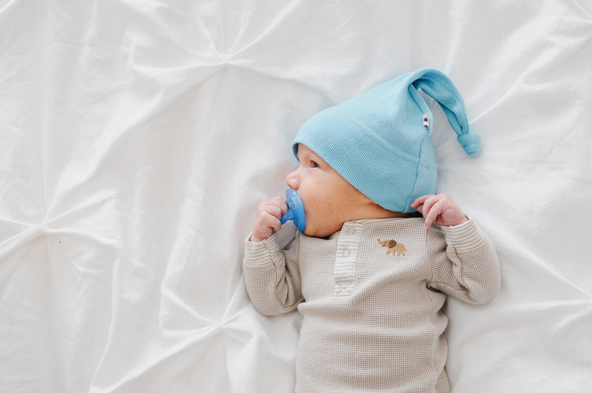 newborn baby boy laying in a crib