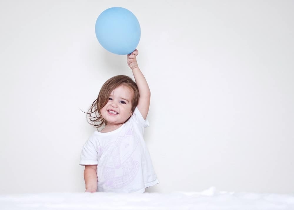 child holding a balloon above their head