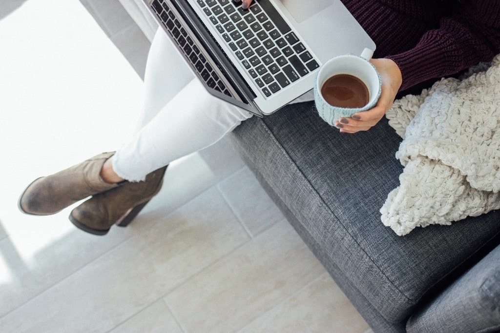 Woman sitting down with laptop and coffee cup