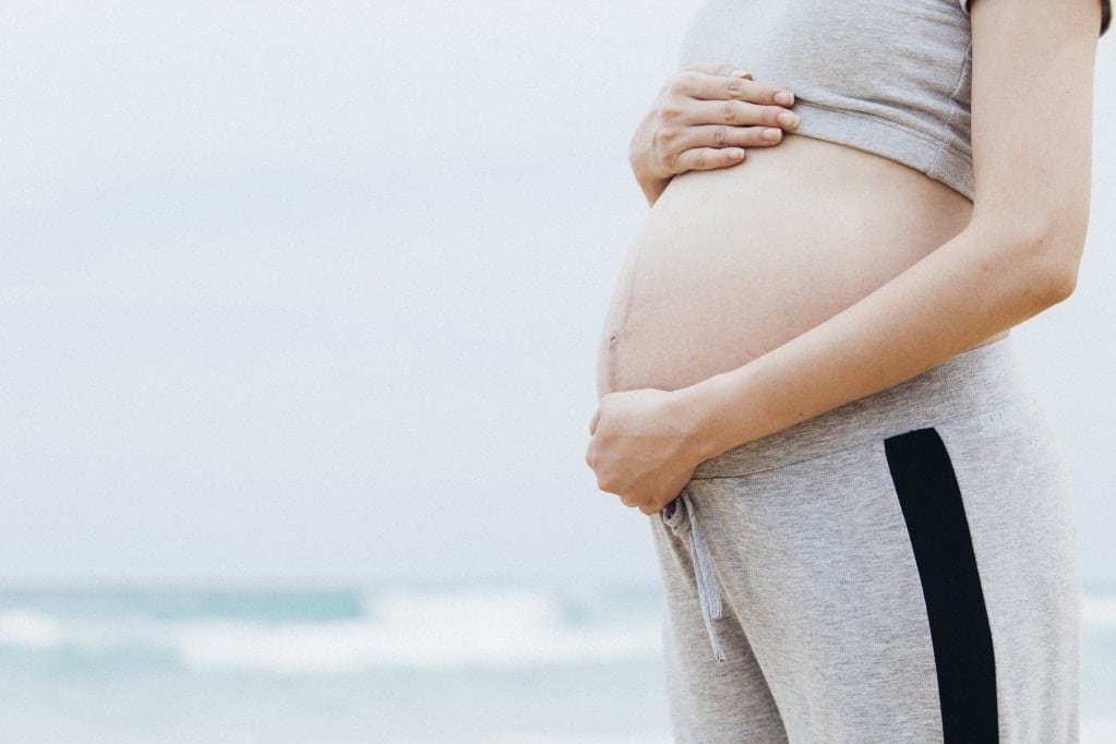 woman cradling her pregnant belly, wondering how to avoid a c section