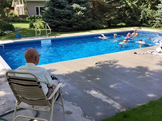 widower looks on at neighborhood pool