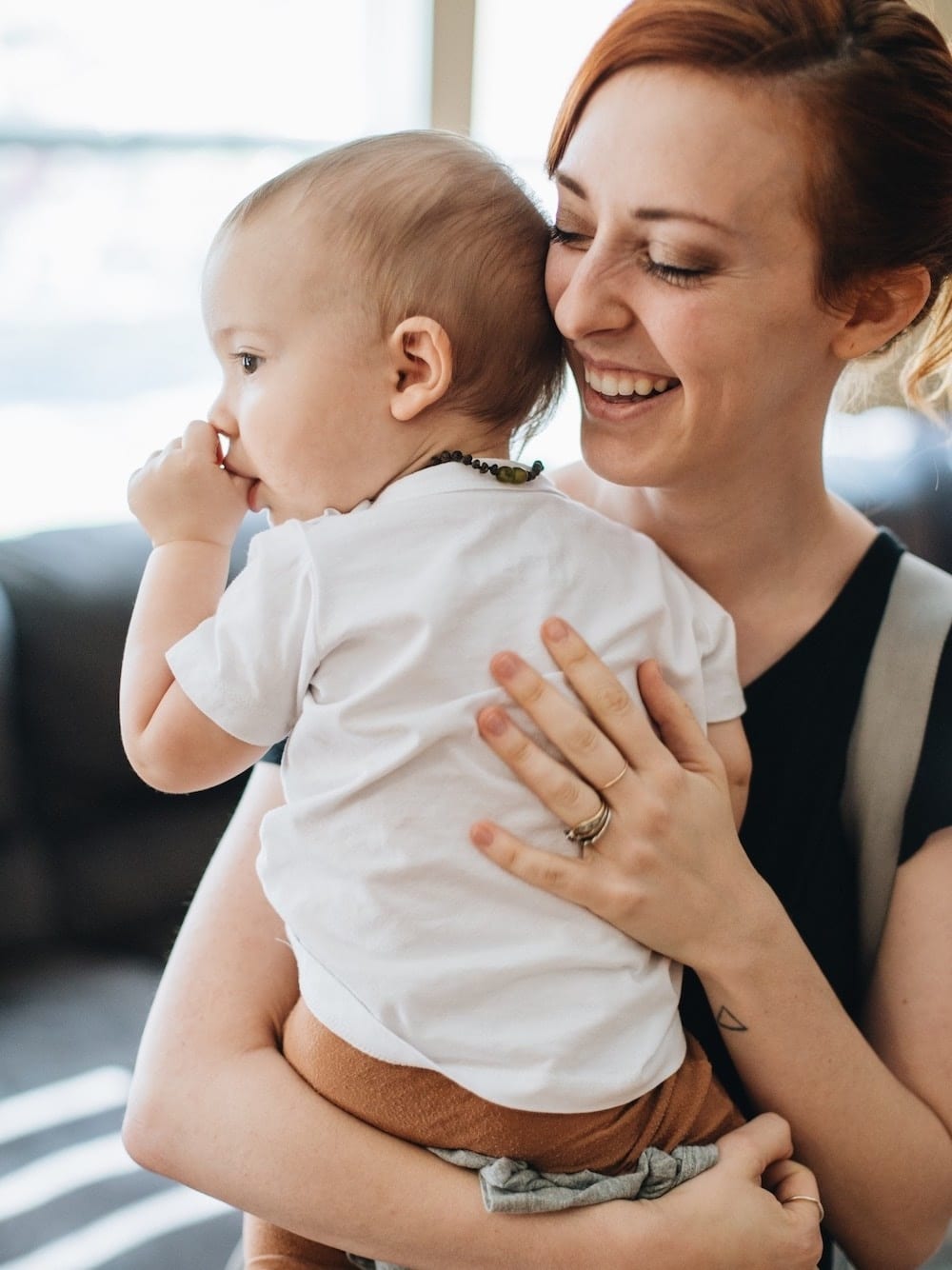 mom holding newborn with a diaper bag on her shoulder