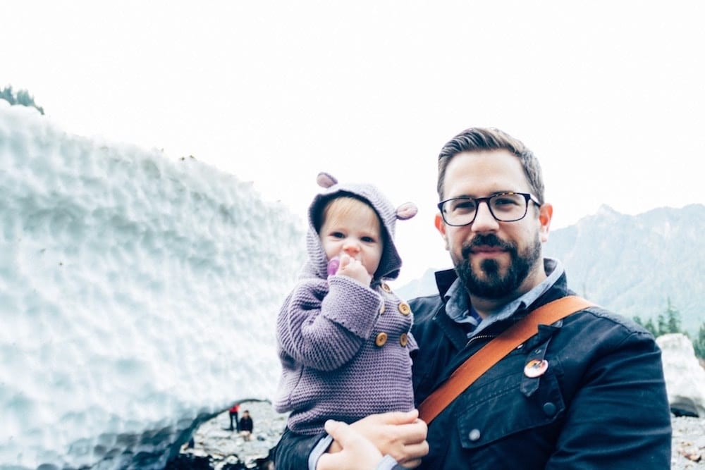 dad holding daughter on a mountain