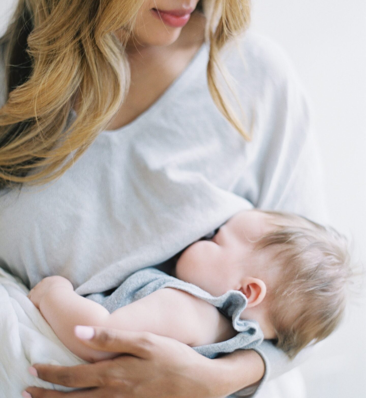 woman breastfeeding baby under her shirt