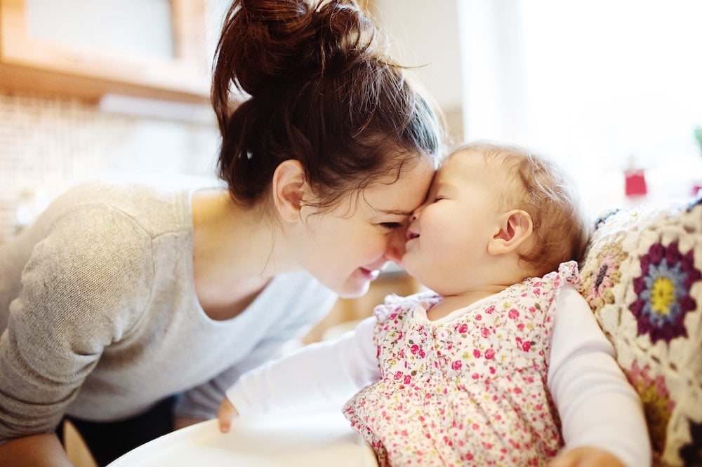 stay at home mom putting her head against her baby's