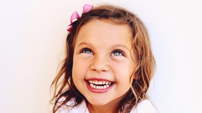 little girl smiling - how to raise a happy child