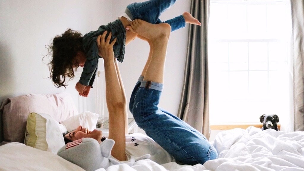 mom playing airplane with toddler