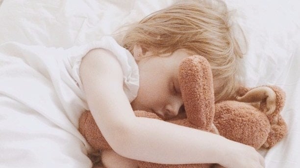 little girl sleeping with a stuffed animal