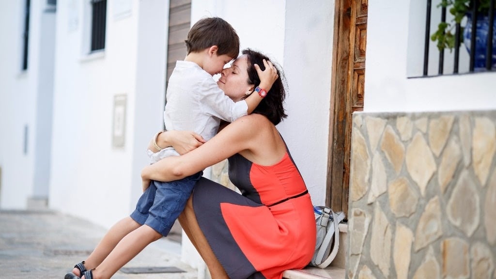 mom hugging and kissing toddler