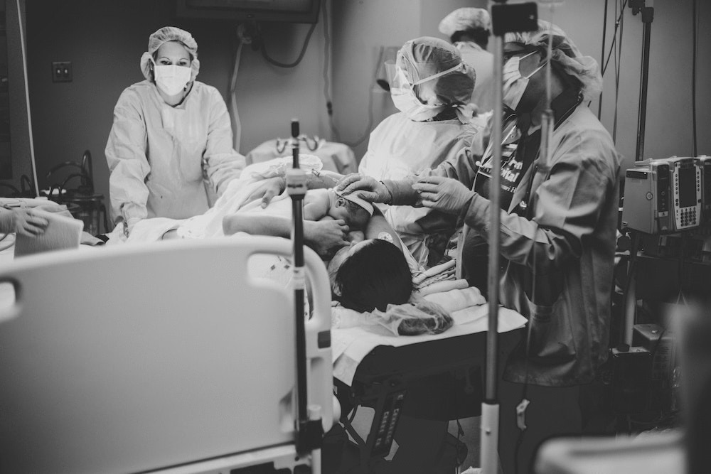 mother giving birth via gentle c-section in the operating room