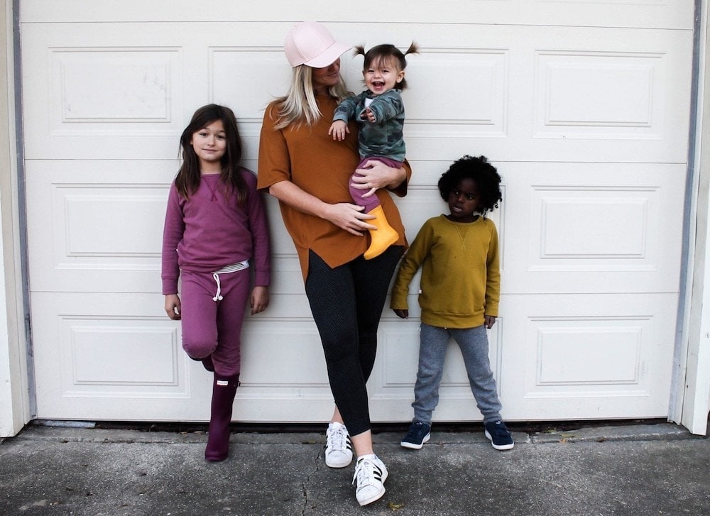 mom taking a picture with three kids