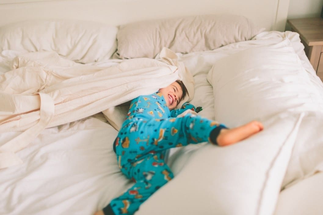 toddler playing in a bed