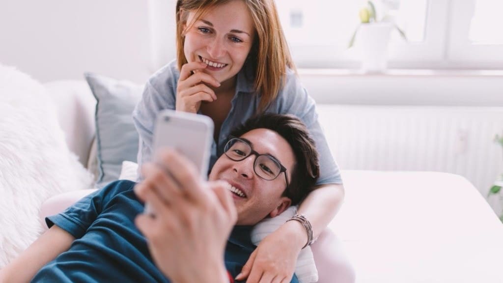 couple looking at a phone snuggling