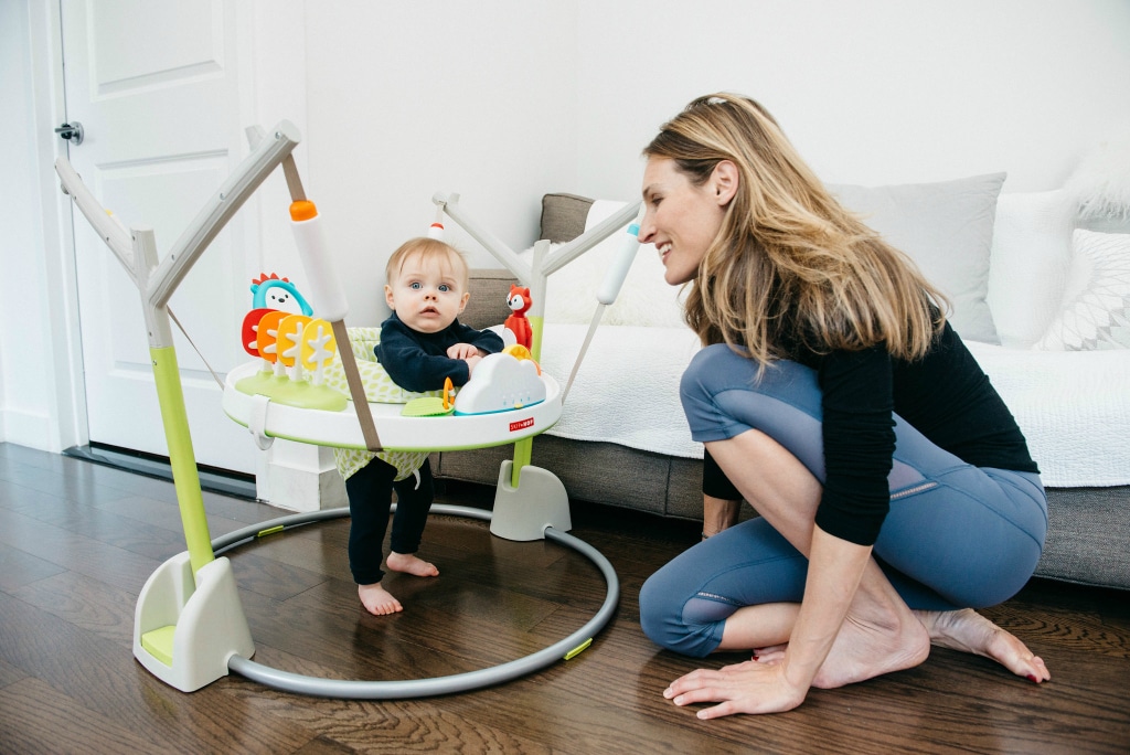 woman watching baby in jumper