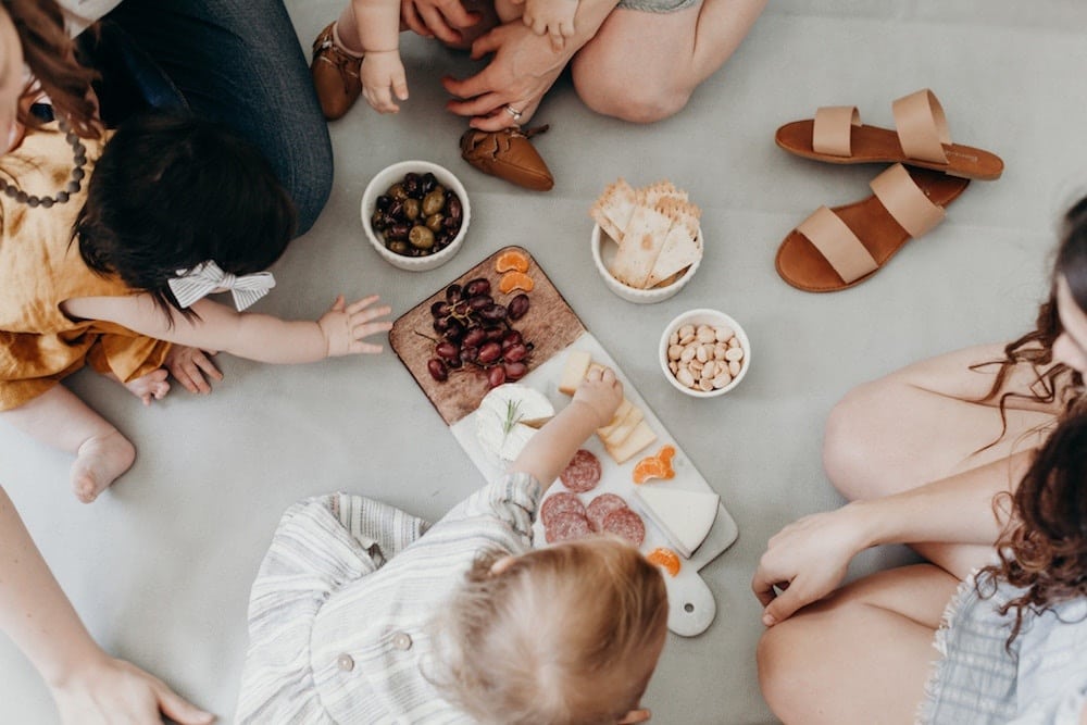 family eating a picnic on a blanket