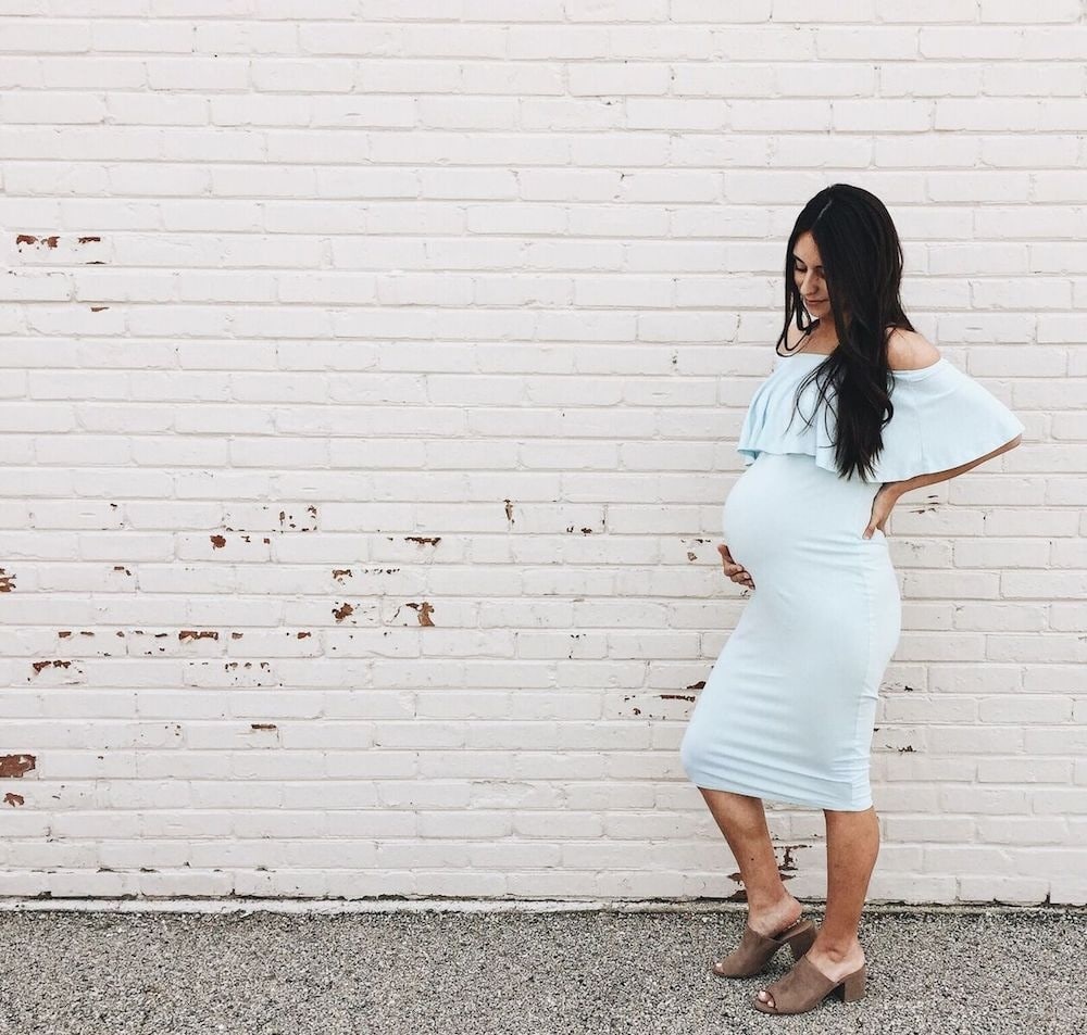 pregnant girl against a brick wall
