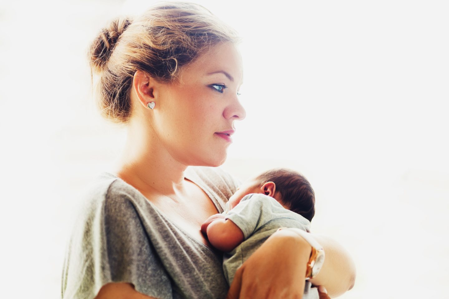 mom holding newborn baby against her chest