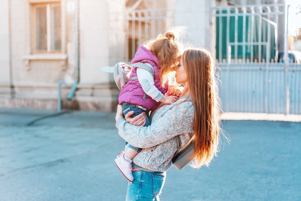 building resilience in kids: mother holding toddler outside in sunlight