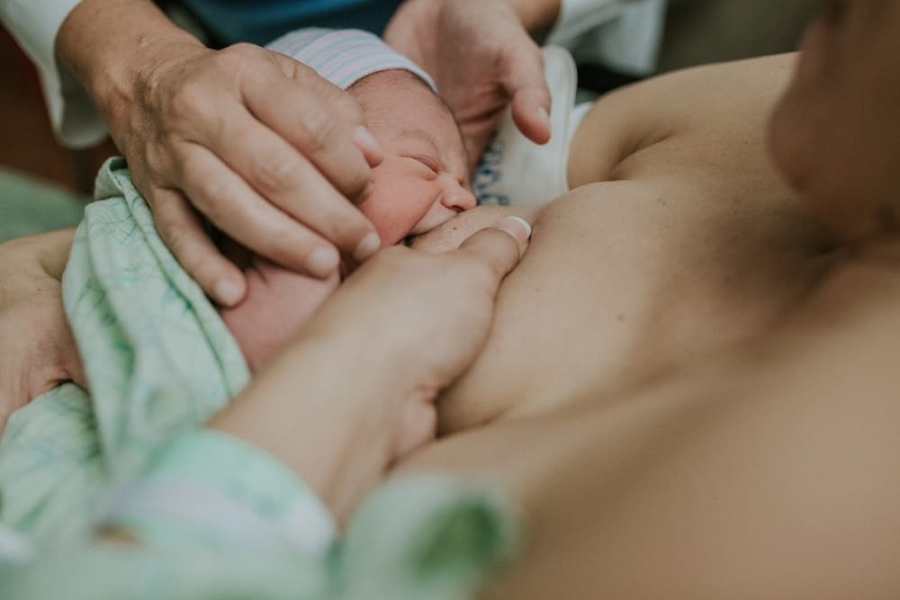 mom breastfeeding newborn in the hospital after birth