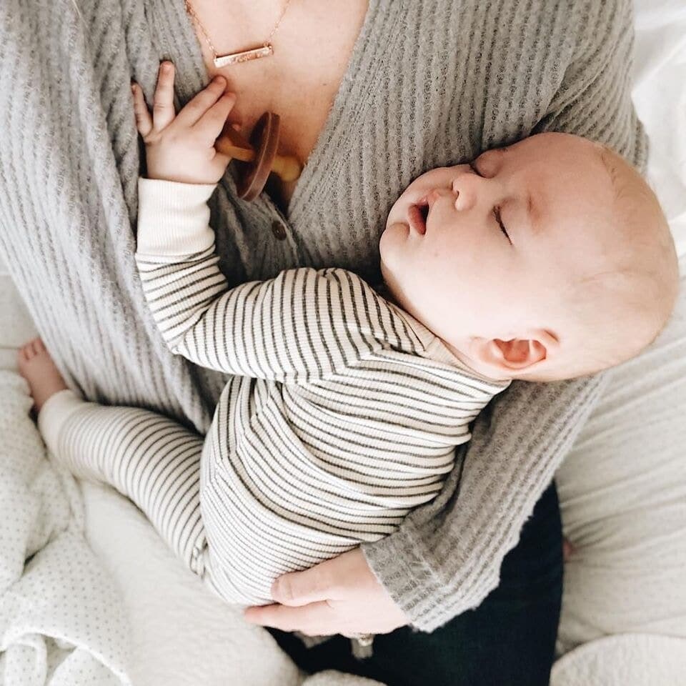 little boy sleeping in moms arms