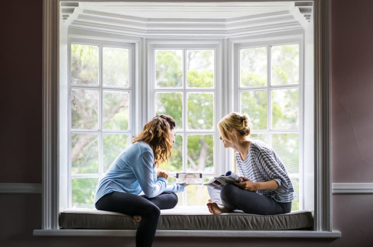 two women drinking coffee together