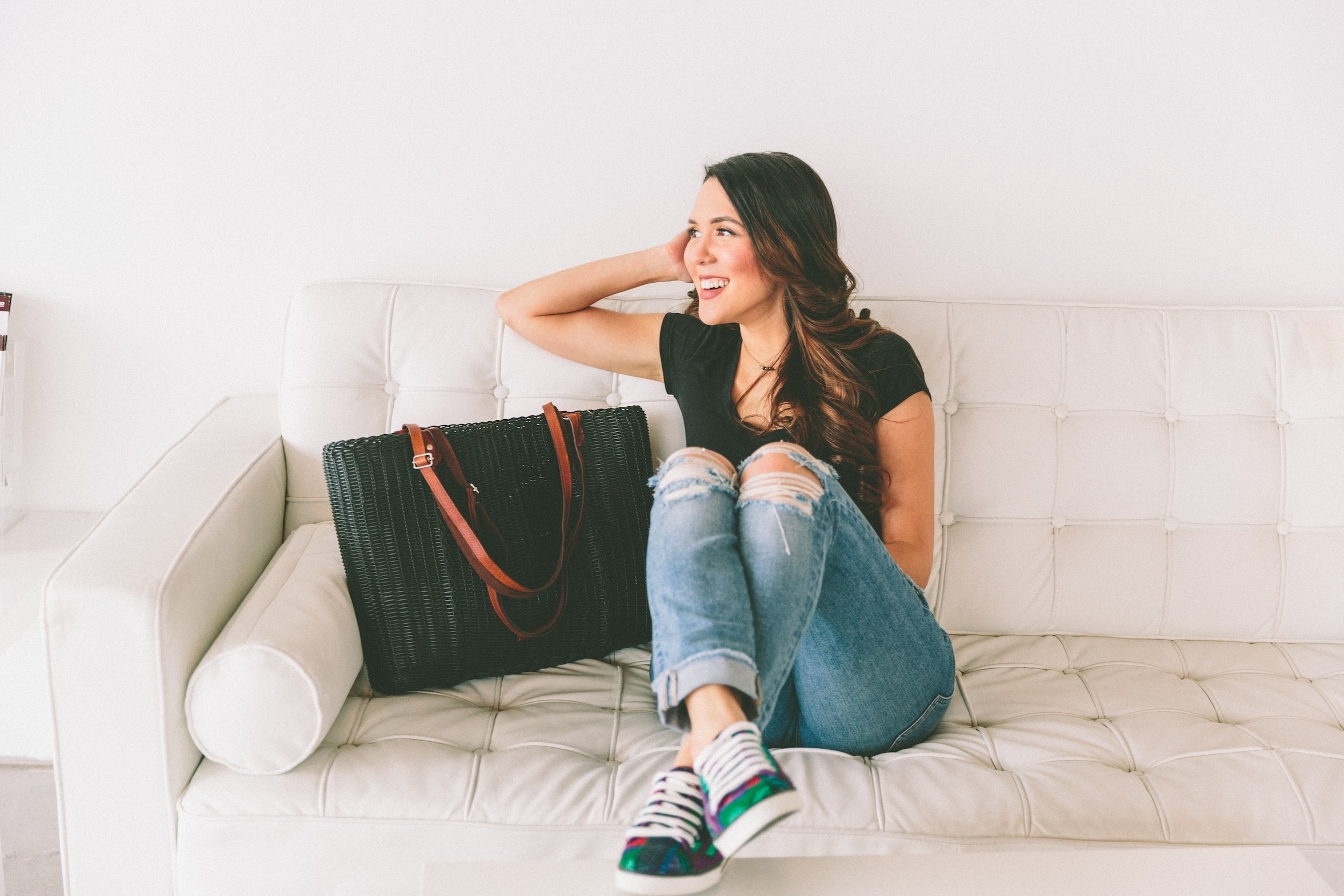 woman sitting on a couch next to purse